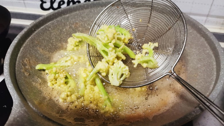椒盐花菜,油锅里放入花菜，炸至金黄熟透