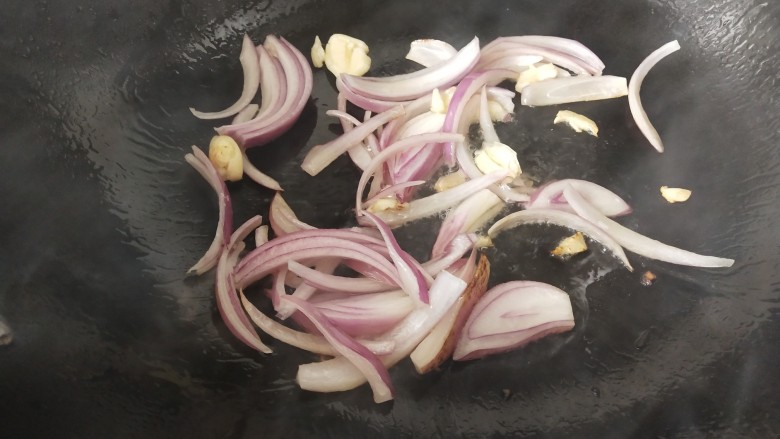椒盐花菜,锅里热油后，放入洋葱和蒜瓣炒香