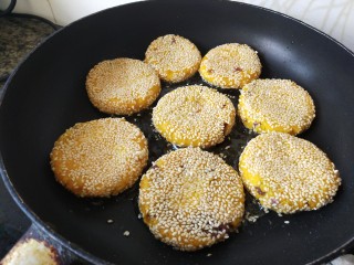 南瓜饼,平底锅里放入油，把南瓜饼一个一个放进去，煎成两面金黄