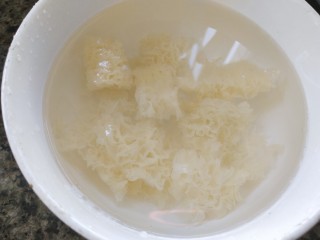 南瓜银耳莲子羹,银耳泡水剪去黄蒂，再剪成一小朵，洗净，放水里泡软
