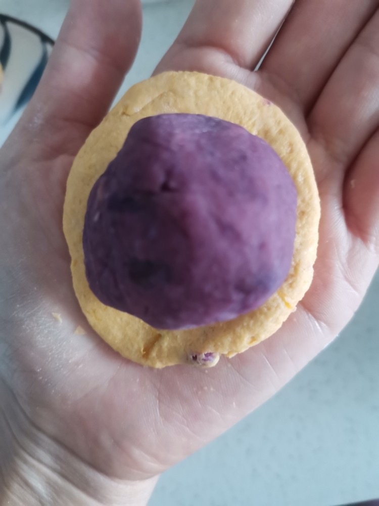 南瓜紫薯月饼,南瓜球按成圆饼，包上紫薯球