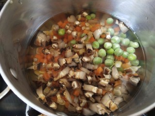 五彩的糯米饭,锅里放开水，倒入玉米粒、青豆、胡萝卜、香菇粒断生