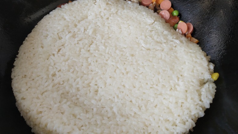 五彩的糯米饭,倒入蒸好的糯米饭，翻炒，把米饭炒散