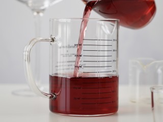 蔓越莓鸡尾酒,3、另外找一个大一些的杯子倒入蔓越莓果汁。