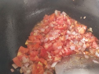 番茄牛肉焗饭,加入番茄翻炒，加适量白糖炒出汁