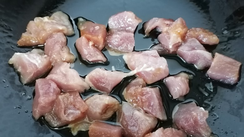 西红柿炖猪肉,锅内放油烧热放入肉块翻炒