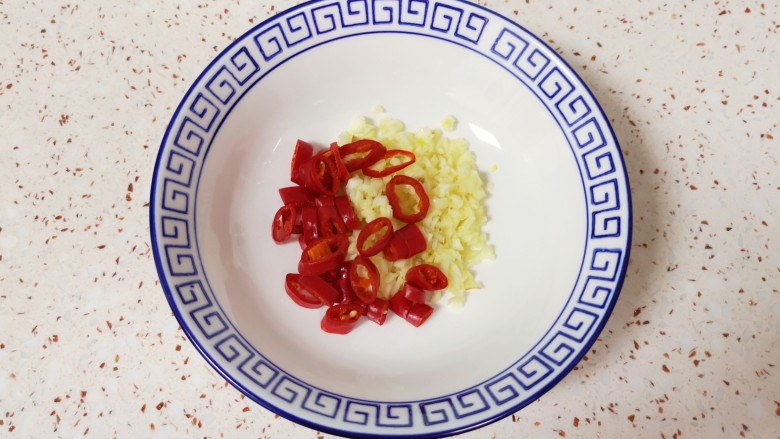 凉拌蒸茄子,将蒜末和红辣椒一起放入小碗里。