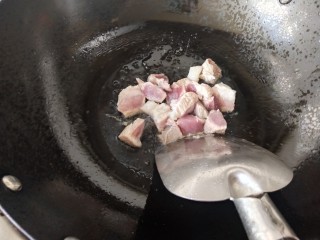 白萝卜炖猪肉,锅里的冰糖融化后，看上去有点焦黄时倒入猪肉块煸炒，炒制变色