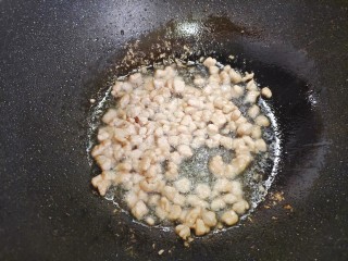 小炒毛豆,起油锅，油热后下肉丁，翻炒至变色