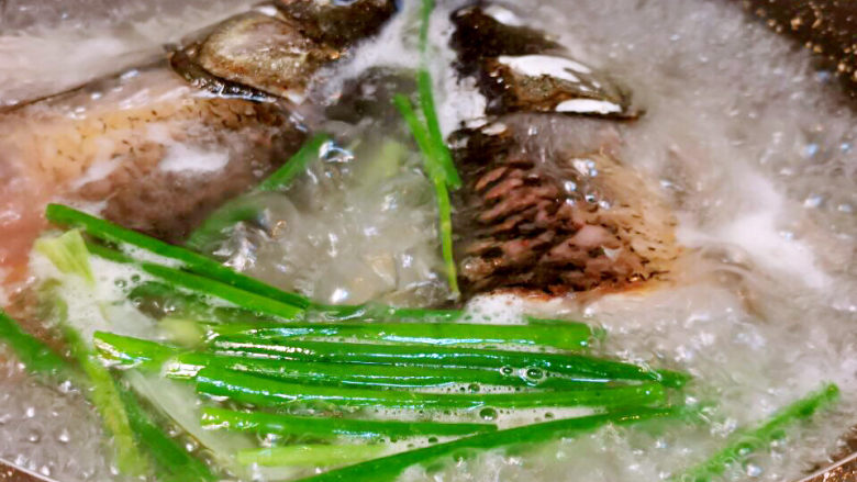 鱼头炖汤,加入葱姜及沸水，小心操作，不要被热水烫伤