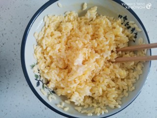 玉米虾仁蛋炒饭,搅拌均匀，使米饭全部粘上蛋液，浸泡一会儿