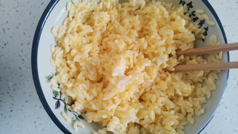 玉米虾仁蛋炒饭,搅拌均匀，使米饭全部粘上蛋液，浸泡一会儿
