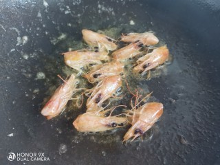 玉米虾仁蛋炒饭,锅烧油下入虾头，煸出虾头油，盛出备用