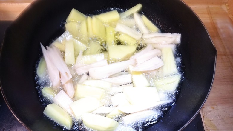 干锅鸭掌,待油温七成热，倒入土豆藕条，转小火炸至熟透