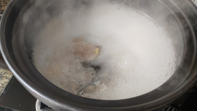 鱼头炖汤,用勺子撇去浮沫，盖上盖子慢火烧20分钟
