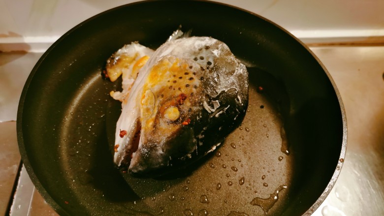 鱼头炖汤,起油锅放入2汤匙食用油，油热后放入鱼头煎至两面微微焦黄色。