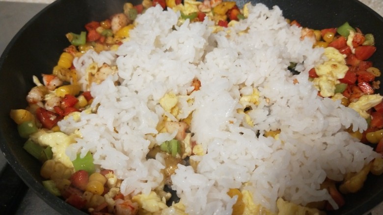 玉米虾仁蛋炒饭,倒入刚蒸好的热米饭。
