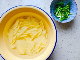 土豆回锅肉,土豆去皮洗净切成薄片，用流动水冲洗两三遍，然后清水内浸泡备用，小葱洗净切寸段