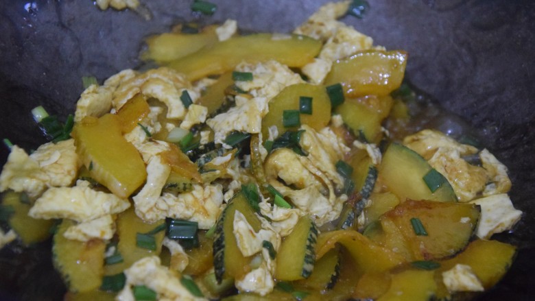 南瓜炒鸡蛋,加入鸡蛋、葱花和酱油，翻炒均匀