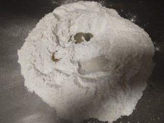 扭藤馒头,面粉放不锈钢板上，里面放上盐，白糖，油，酵母拌匀