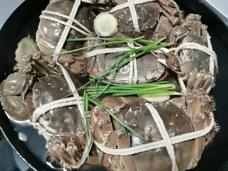 蟹肉粥,蟹入锅加水、葱、姜、料酒煮开