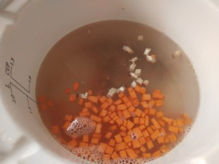 蟹肉粥,炖锅里一次性放入足量的开水，放入胡萝卜丁和香菇丁开始烧
