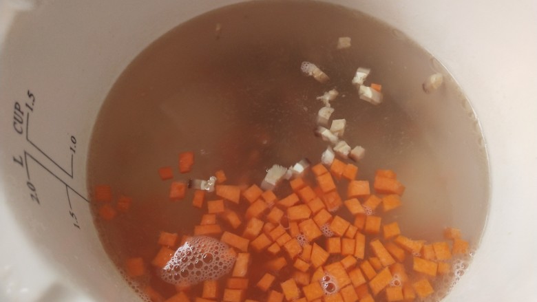 蟹肉粥,炖锅里一次性放入足量的开水，放入胡萝卜丁和香菇丁开始烧