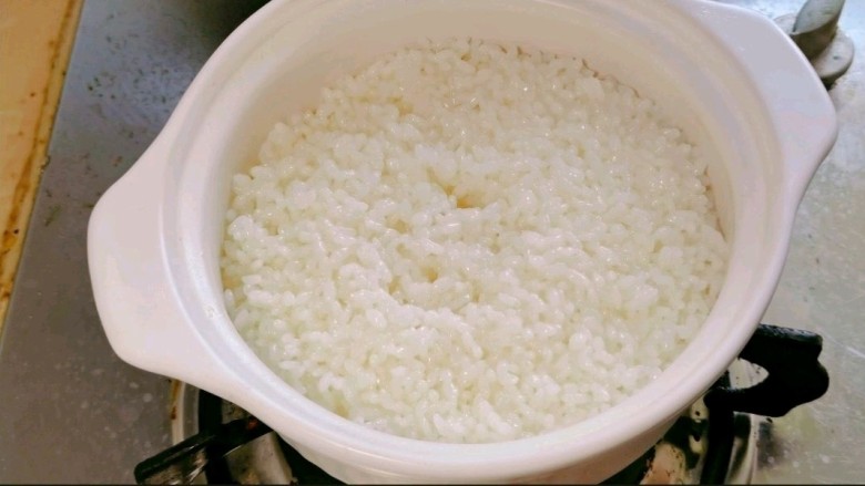 暖冬煲仔饭,米饭煮至七分熟☺️，用筷子插几个气孔