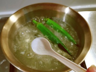 秋葵鸡蛋卷,秋葵清洗干净放入开水中煮1-2分钟捞出，水中加入2克盐。