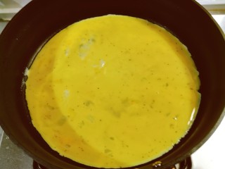 秋葵鸡蛋卷,起油锅，薄薄地刷一层食用油，倒入鸡蛋液。