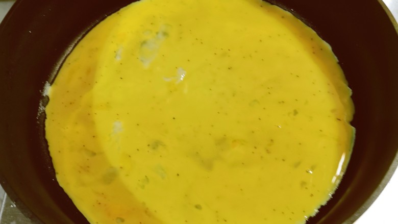 秋葵鸡蛋卷,起油锅，薄薄地刷一层食用油，倒入鸡蛋液。