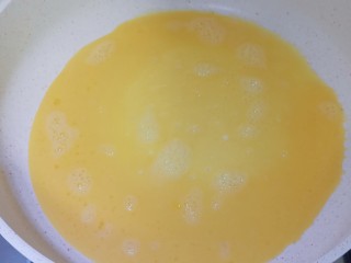 秋葵鸡蛋卷,油热后加入1/3的鸡蛋液