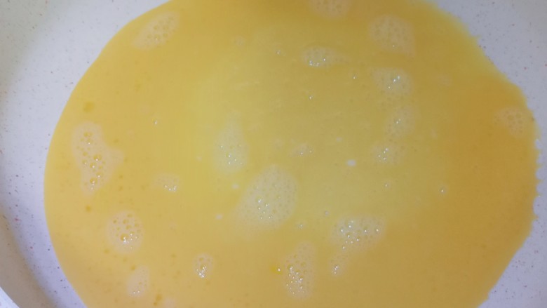 秋葵鸡蛋卷,油热后加入1/3的鸡蛋液