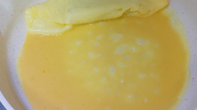 秋葵鸡蛋卷,再倒入1/3的鸡蛋液，微微凝固之后继续卷起来，剩下的鸡蛋液也是同样的操作