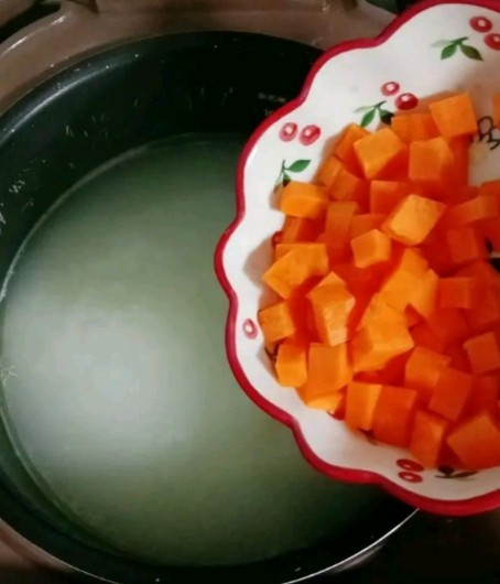 干贝肉沫蔬菜粥,大米煮至开花时，倒入胡萝卜丁