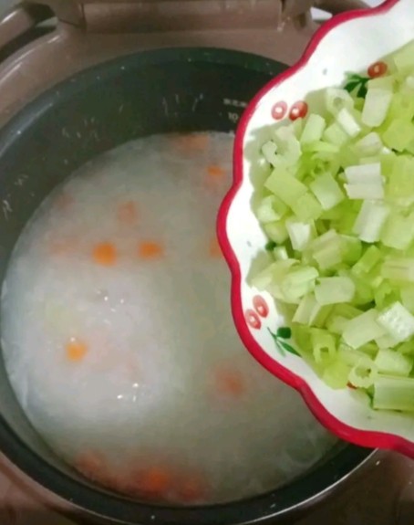干贝肉沫蔬菜粥,胡萝卜煮烂后倒入芹菜丁