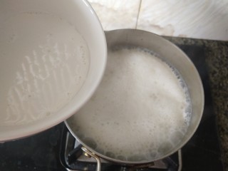 椰丝牛奶小方糕,煮沸时，将拌匀的玉米淀粉和牛奶的混合液倒在锅里