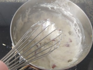 椰丝牛奶小方糕,用打蛋器不停地搅动，几秒钟原来流动的液体变粘稠了。