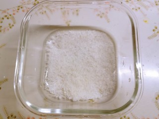 椰丝牛奶小方糕,取一合适的器皿，底部撒一层椰蓉。