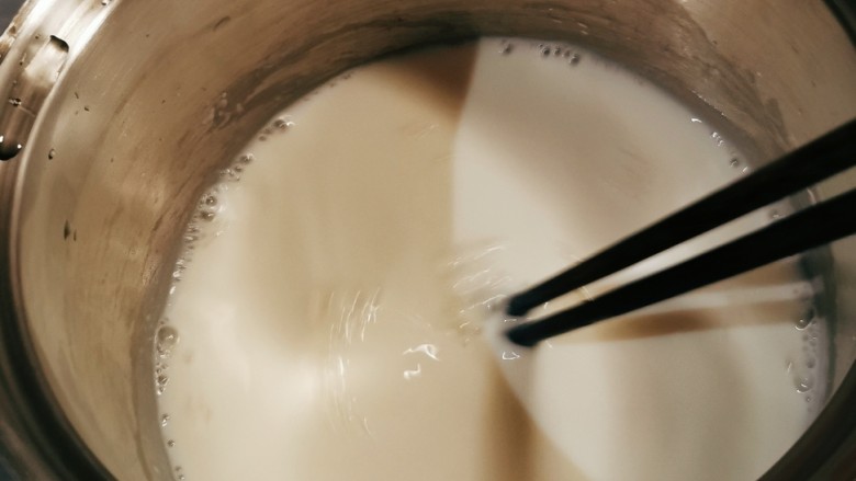椰丝牛奶小方糕,边加热边不停地搅拌。