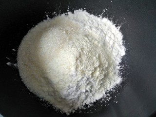 椰丝牛奶小方糕,将玉米淀粉、奶粉和白糖加入不粘锅