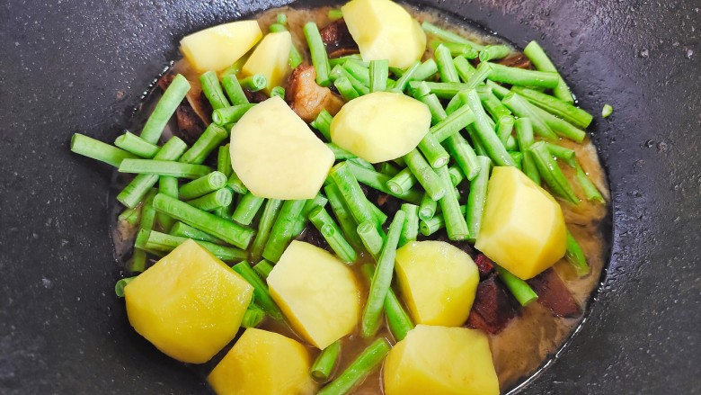 排骨土豆炖豆角,加入土豆和豆角，盖上锅盖，继续小火焖煮15~20分钟