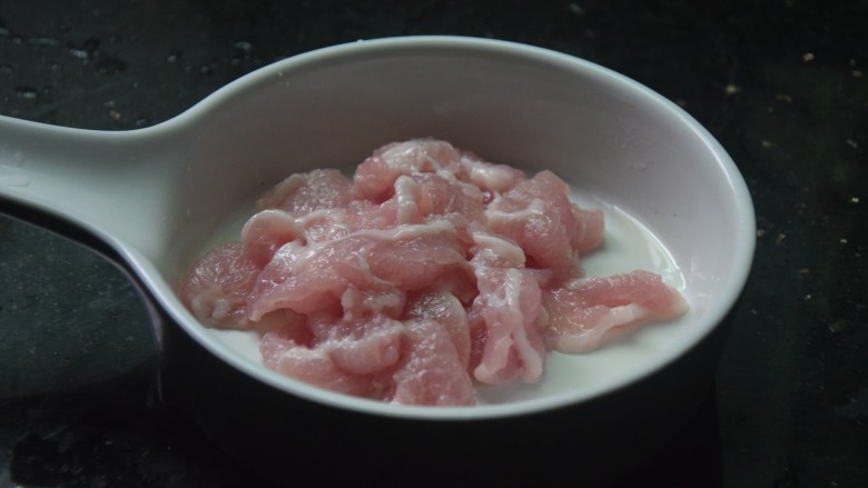 青菜猪肉粥,猪肉切小块，加入小苏打和食用油抓匀
