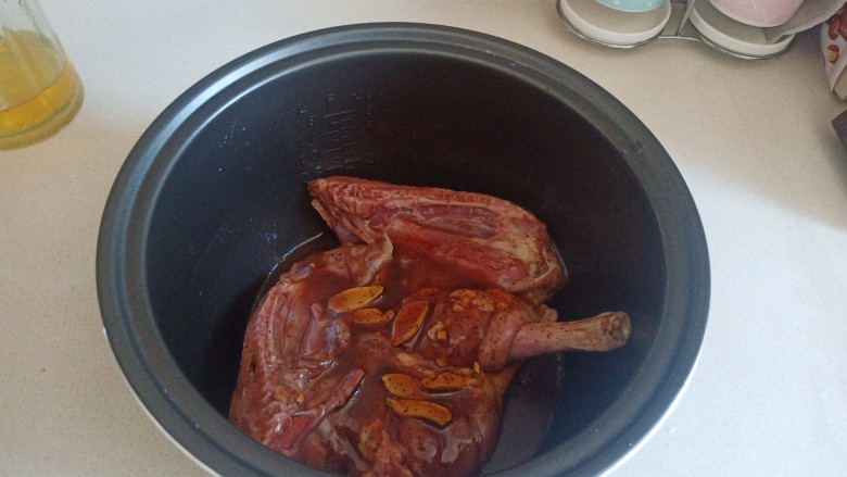 香酥鸭腿,电饭锅中刷一层油，加入腌制好的鸭腿，按下煮饭键。