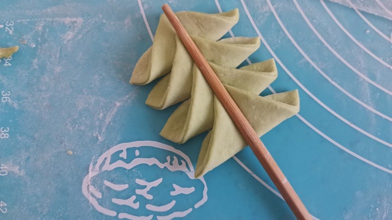 菠菜柳叶馒头,再把每一瓣的直角向弧线中间折，再依次用筷子压一下