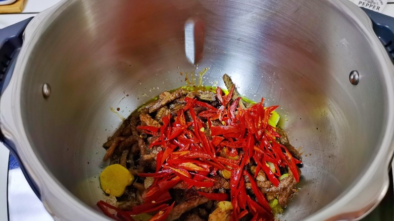 青椒爆炒牛里脊,加入辣椒丝，盖上盖子翻炒3分钟。