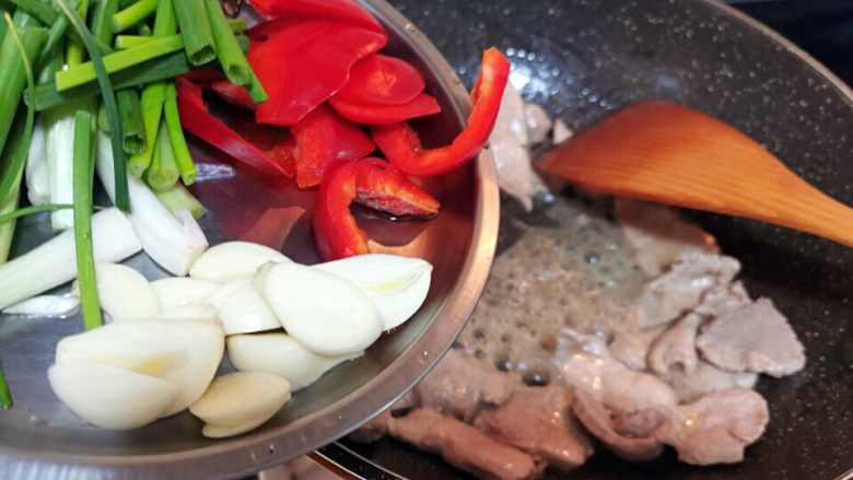 蘑菇炒肉片,肉片变色后，加入葱蒜爆香