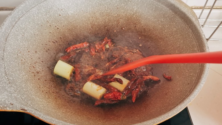 红焖牛肉煲,放入辣椒，葱段，姜片爆出香味