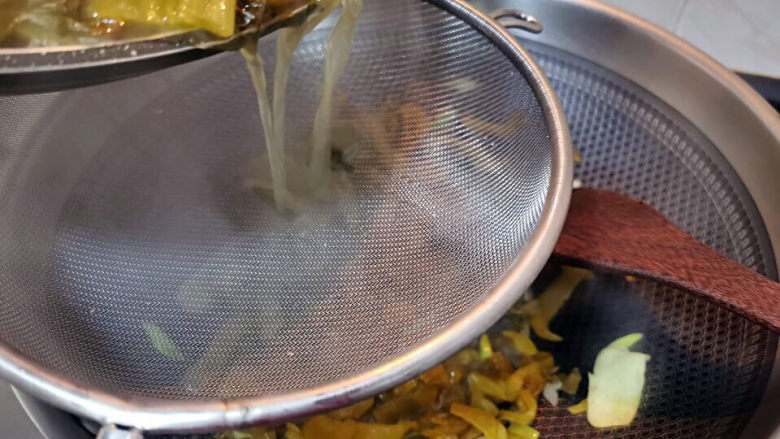 酸菜海鲜锅,酸菜帮子放入锅中，加入过筛的酸菜高汤，煮开后，加入糖，盐，鸡精调味。