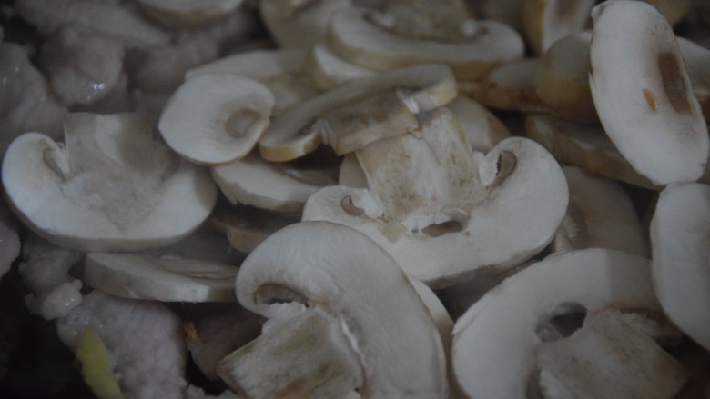 蘑菇炒肉片,倒入蘑菇片，加入少许清水翻炒至变软